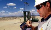 BP employee monitoring well sites on his PDA